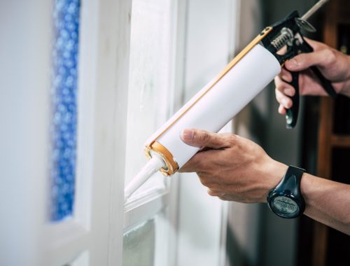 carpenter-holds-glue-attaches-window